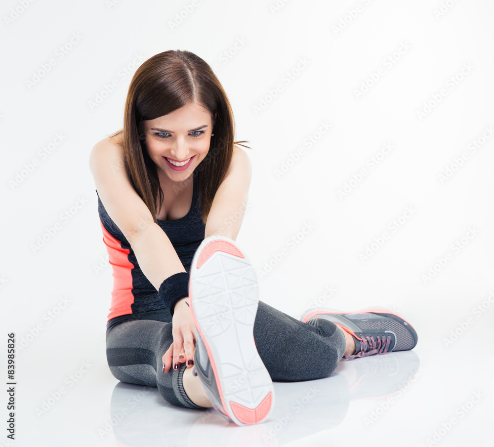 Wall mural Smiling fitness woman doing stretching exercises