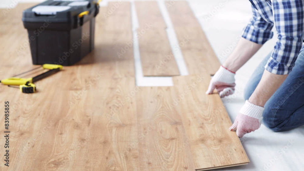 Wall mural close up of man installing wood flooring