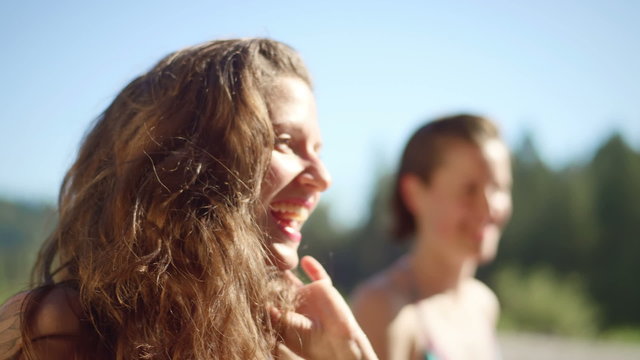 A girl laughs and talks with her friends, close up shot