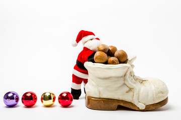 Santa Claus neben einem Schuh voller Nuesse