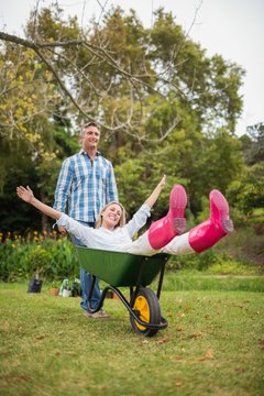 Happy couple playing with a wheelbarrow 