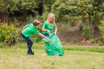 Fototapeta premium Happy siblings collecting rubbish 
