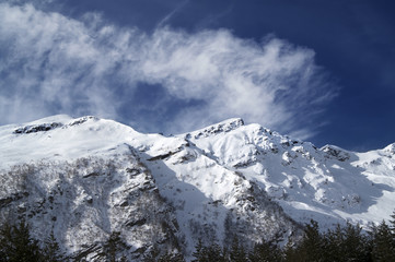 Fototapeta na wymiar View on off-piste ski slope at sun windy day