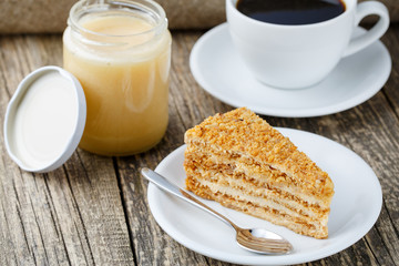 Tasty honey cake with jar of honey.