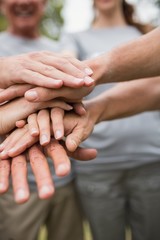 Happy volunteer family putting their hands together 