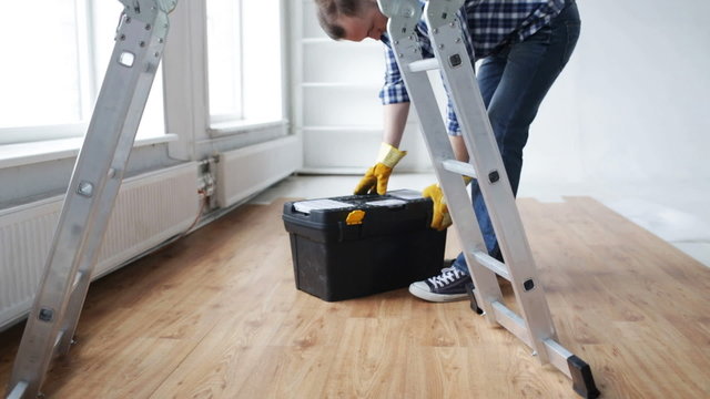 close up of man bringing tool box and ladder