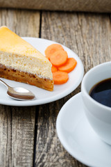 Sweet slice of carrot cake with coffee cup.