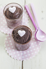 Dunkle Schokoladenmousse in Gläsern, weißesHolz, pinke Löffel