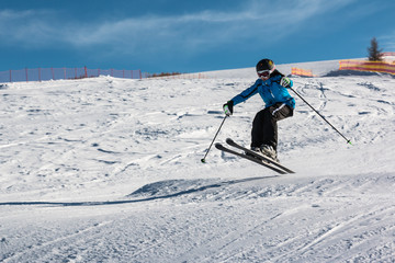 Fototapeta na wymiar Little skier performs jump in the snow
