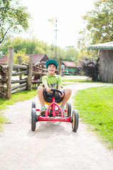 happy boy on a peddle go-cart having fun