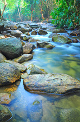 Fototapeta na wymiar Water Flow Through Rocks In A Shallow Stream in Malaysia Jungle