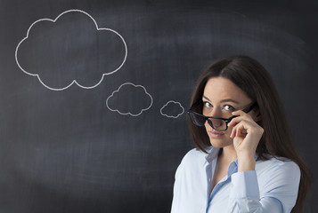 Businesswoman in front of blackboard with thought bubble