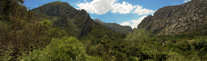 green slopes of the mountains and white clouds