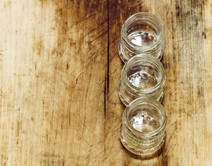 Empty small glass jar on a wooden table, selective focus