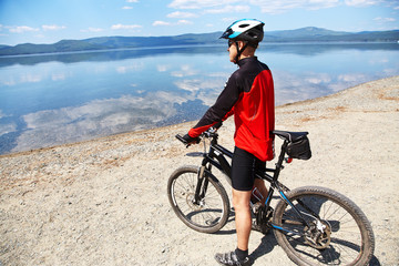 man with bike on a mountain lake