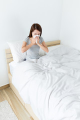 Obraz na płótnie Canvas Asian woman feeling sick and sneeze at living room