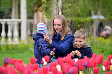 Mother And Children Relaxing around  flower beds