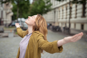 frau in der stadt breitet die arme aus