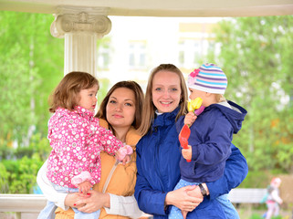 Two mothers with children on the walk in  gazebo