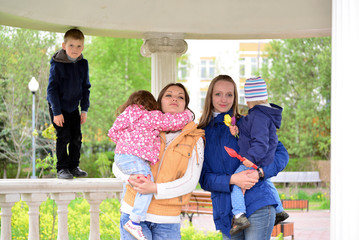 Two mothers with children on the walk in  gazebo