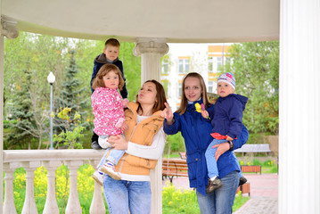 Two mothers with children on the walk in  gazebo