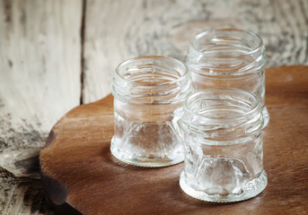 Empty small glass jar on a wooden table, selective focus
