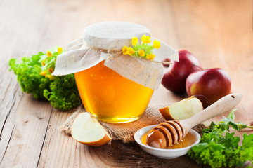 Pot of honey and wooden stick