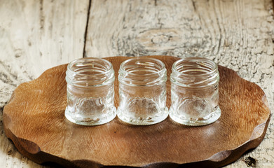 Empty small glass jar on a wooden table, selective focus