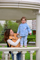 Fototapeta premium Mom and daughter 2.5 years for a walk in gazebo