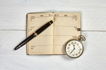 Antike Füllfeder und alter Kalender auf weißem Schreibtisch - 83998432