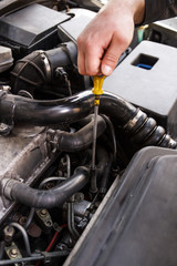 Obraz premium Mechanic checks the oil on a car being repaired