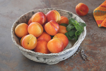 Beautiful ripe apricots in a ceramic bowl, close up