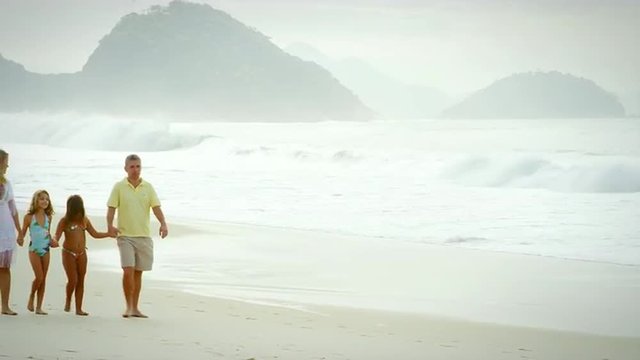 Brazilian family walking down a beach in Brazil
