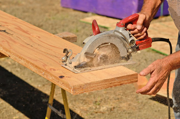 held worm drive circular saw to cut boards