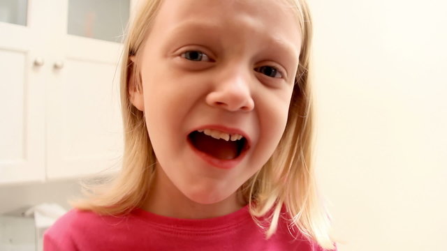 Cute little girl wiggles loose tooth and tries to pull it out
