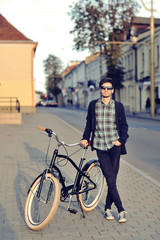 Young hipster man with retro bike