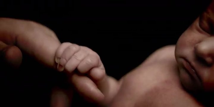 Baby grabs a finger and holds onto it.