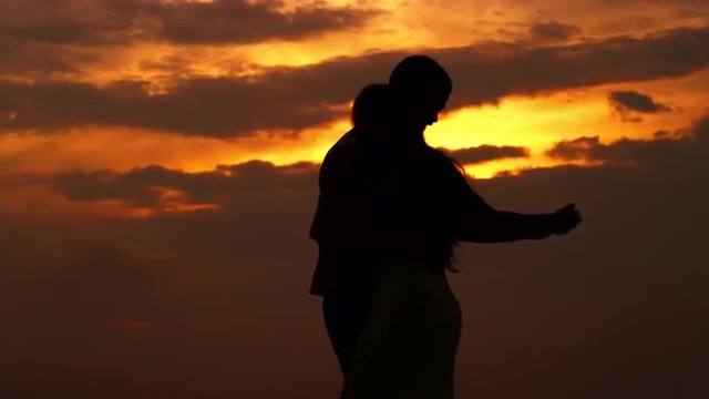 couple dance on a beach  at sunset
