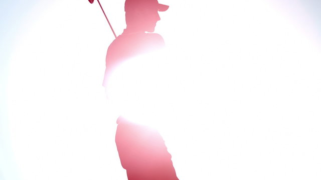 A golfer swings the golf club on a blue bird day
