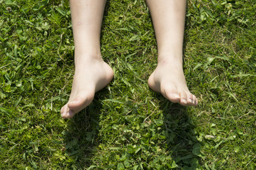 Feet of boy lying down on the grass