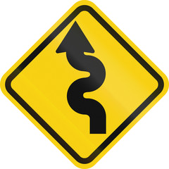 Colombian road warning sign: Winding road, left version