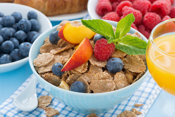 breakfast with flakes fruits and berries, orange juice 