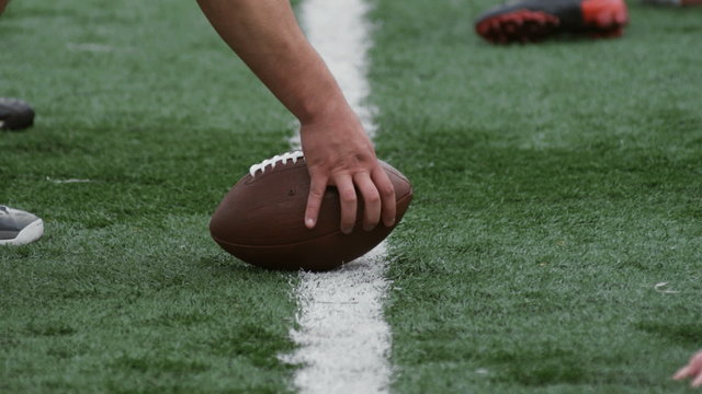 A Quarterback passes the ball as the two sets of lineman battle for position.