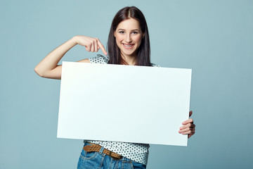 Beautiful woman standing behind, holding white blank advertising