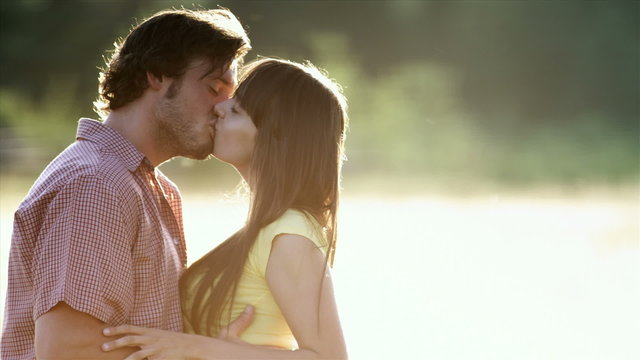 Beautiful Young Couple in Love Kiss then Turn And Look at the Camera