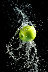 Green apple with water splash, on black © ArtushFoto