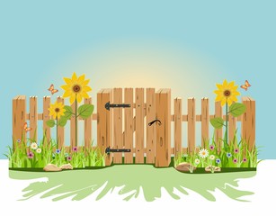 A wooden gate and fence with green grass and flowers