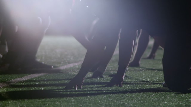 Close up view of football player's hands on the ground ready to snap the ball
