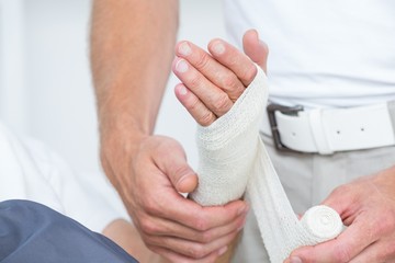 Obraz premium Doctor bandaging his patient hand