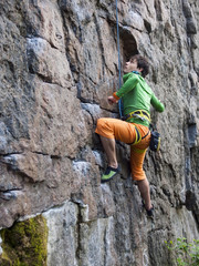 Rock climber climbs the wall.
